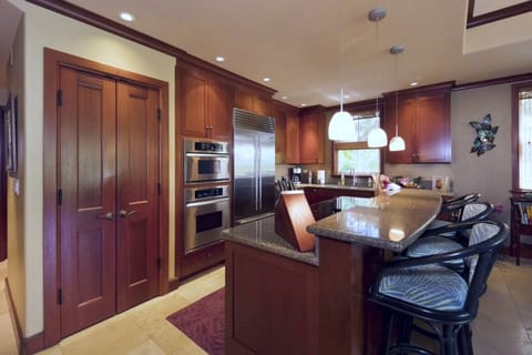 Spacious kitchen with wood cabinetry, pendant lights, and a breakfast bar for casual gatherings.