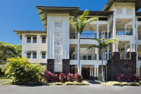 Exterior of a stylish tropical villa with balconies, beautiful landscaping, and classic island charm.

