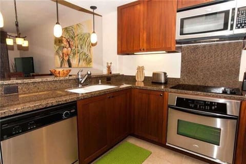 Cook with ease in this fully equipped kitchen featuring granite counters, rich wood, and sleek steel.


