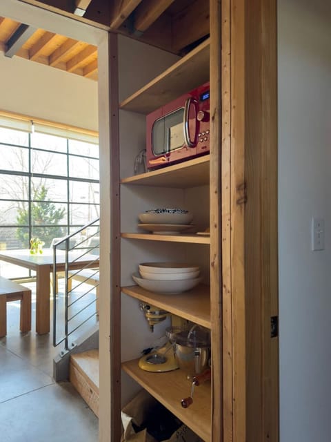 Convenient shelving with a microwave and dishes for your comfort.