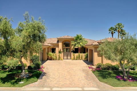 Welcoming front entry framed by lush landscaping & a warm, inviting facade