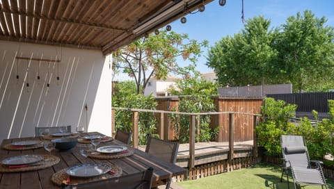 Terrace opening onto the garden with barbecue and garden furniture