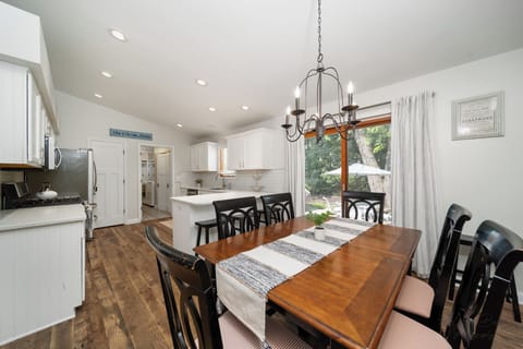 Open concept kitchen with dining table for up to 6 guests and island seating for 3 guests, and easy access to back yard.