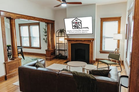 Welcome to The Sandstone — a warm, inviting living room with classic woodwork, a Smart TV, and comfortable seating, perfect for relaxing after a day in Kansas City’s Midtown.