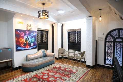 An inviting lounge area outside the bedroom, filled with sacred ambiance and warm, peaceful light — the essence of Shiva Nirvana Loft.”