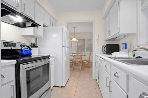 Kitchen freshly repainted and refreshed, featuring a brand-new refrigerator and stove installed in 2025.