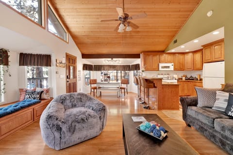 Cozy mountain living room with a stone fireplace, comfy seating, and smart TV—perfect for relaxing evenings, movie nights, and warm cabin vibes after outdoor adventures.