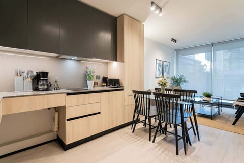 Modern kitchen and dining area with sleek design, abundant natural light, and stylish decor for a cozy dining experience.