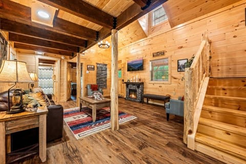From the sturdy wood staircase to the colorful rug and flickering fire, this open-concept great room is where mountain charm meets everyday comfort.