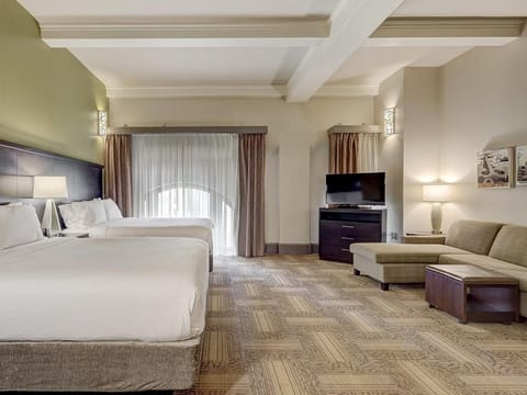 Unwind in a spacious suite with beds and cozy lounge.