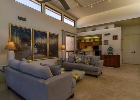 Relax in this stylish open concept lounge where island artwork and vaulted ceilings set the tone.