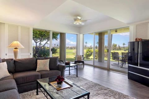 Relax in a sunlit living room with panoramic golf course views and seamless lanai access.