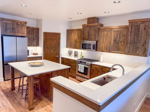 Enjoy cooking in this spacious, fully equipped kitchen featuring stainless steel appliances, rich wood cabinetry, and a central island—perfect for casual breakfasts or prepping dinner after a day in the mountains.