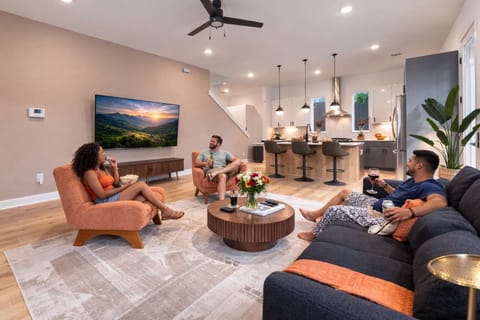 Living room with smart TV and open kitchen, perfect for relaxing.