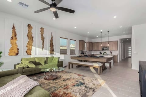 Relax in the spacious living room with plush seating, a smart TV, and a sleek pool table that doubles as a dining table, perfect for both game nights and enjoying a nice meal. 