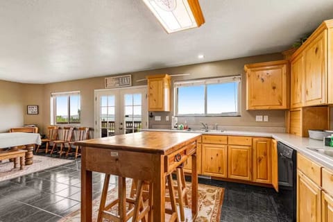 This spacious kitchen opens to a dining area with expansive windows and mountain views, perfect for group meals and entertaining.
