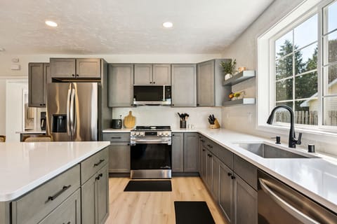 Modern stainless steel appliances make it easy to cook with a glass of wine!