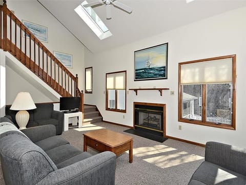 Spacious and inviting living area with high ceilings, a cozy fireplace, and ample natural light—perfect for relaxing after a day at the beach.