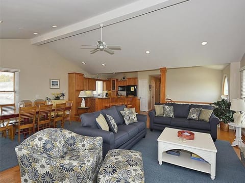 Delight in the expansive open-concept living area where luxury meets comfort, complete with vibrant décor, ample seating, and natural light pouring in from large windows overlooking the ocean.