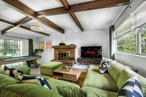 Living room with smart TV, fireplace, and pool table