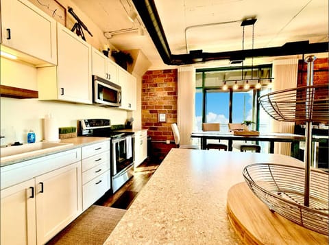 Chef’s Eye View
From the prep island to the brick-accented walls and wide-open patio door, every inch is designed for ease and inspired by the water beyond.