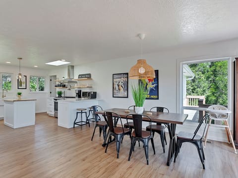Open concept dining area and kitchen with natural light and deck access