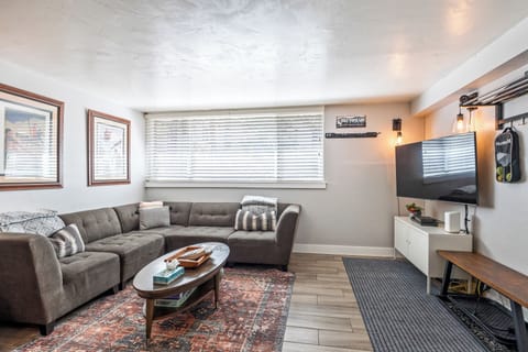 - Cozy living room with sectional sofa and smart TV  
- Bright space with large windows and natural light  
- Perfect vacation rental for family entertainment