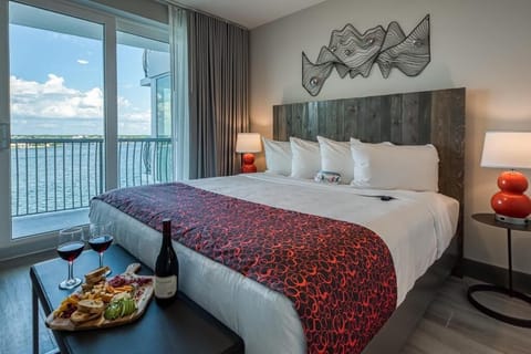 Unwind in plush bedding with breathtaking waterfront balcony views.