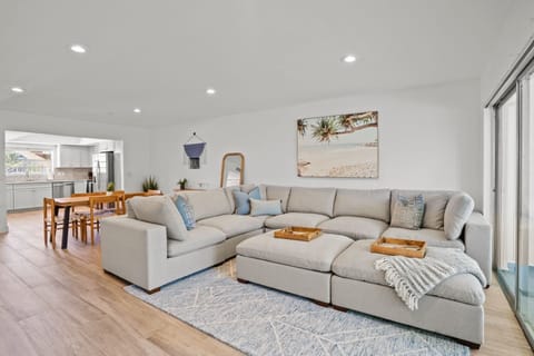 Unwind in comfort in our Unit 1 living room! 🛋️ Relax on the large sectional and enjoy a movie on the 65-inch TV after a long, wonderful day at the beach. 🎬🏖️
