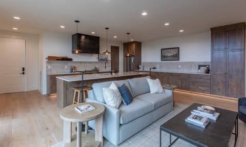 Stylish living room with warm wood accents, modern furnishings, and open flow into the kitchen.