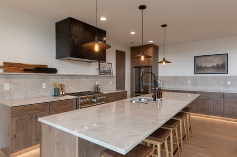 Chef’s kitchen featuring high-end appliances, quartz countertops, and ample seating.