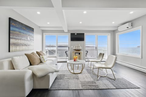 Modern lakeside living room with stunning waterfront views, plush seating, and natural light pouring through sliding glass doors—perfect for relaxing by the lake. 🌅🛋️☕