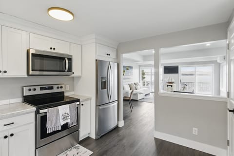 Modern lakeview kitchen featuring stainless steel appliances, white shaker cabinets, and sleek countertops – perfect for home-cooked meals with a view.