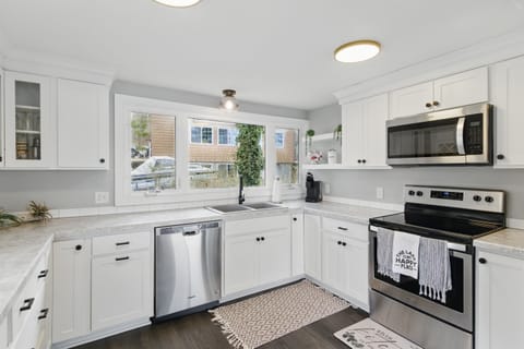 Modern lakeview kitchen featuring stainless steel appliances, white shaker cabinets, and sleek countertops – perfect for home-cooked meals with a view.