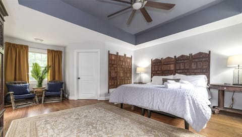 Spacious Primary Bedroom featuring a king bed, spacious walk-in closet, lounging nook, and private en suite bathroom.