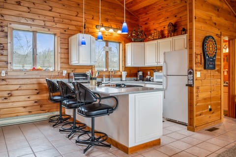 Enjoy a spacious and modern kitchen with sleek black bar stools, perfect for casual dining and socializing.
