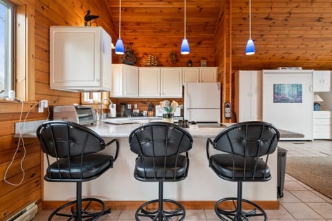 Enjoy a spacious and modern kitchen with sleek black bar stools, perfect for casual dining and socializing.
