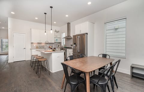 Unit 2: Living room boasts an open-concept layout with comfy seating, a patterned rug, and large windows that bathe the room in natural light.