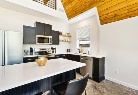 Tucked off the main living space, the sleek black-and-white kitchen keeps things clean, modern, and super functional.