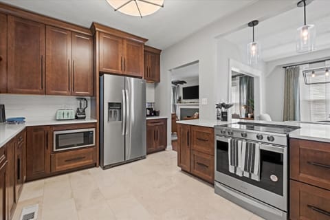 Enjoy a fully stocked, modern kitchen featuring stainless steel appliances, rich wood cabinetry, and everything you need for home-cooked meals during your Hyde Park stay.