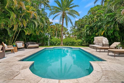 Another view of the inviting pool area highlights the comfortable lounge chairs and the tropical ambiance created by the surrounding palms.
