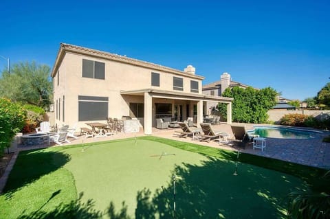 The whole backyard setup – pool, putting green, and space to spread out and play.