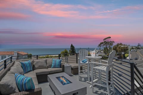 Breathtaking rooftop lounge with panoramic ocean views and a cozy fire pit.