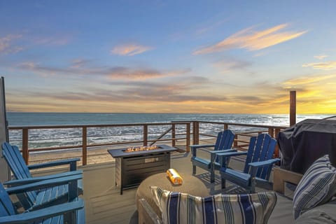 Breathtaking sunset views from the oceanfront deck with a cozy fire pit.