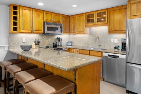 Spacious kitchen with granite countertops with bar seating for 4. Fully stocked with full size appliances and everything guests need for comfortable meal preparation.