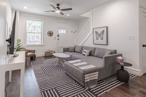 Enjoy a spacious living area with a comfortable sofa, Smart TV for movie nights, and a ceiling fan that adds an extra touch of comfort during warm days or cozy evenings