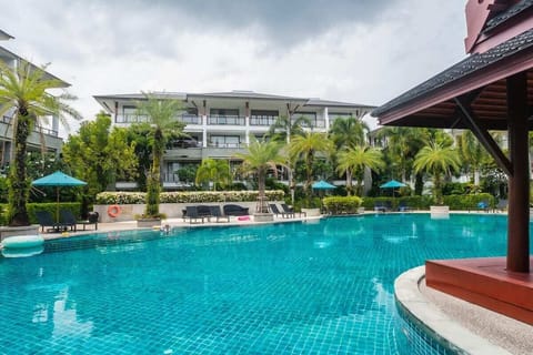 Resort pool surrounded by tropical gardens and landscaped greenery