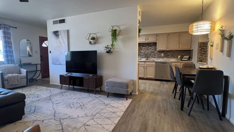 Living room with 55" Smart tv & view of kitchen.