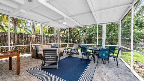 Relax and dine al fresco in the spacious screened-in porch, complete with comfortable lounge seating, a ceiling fan, and outdoor dining for six—all surrounded by lush tropical greenery.