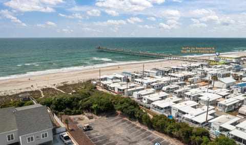 Aerial view of beachfront property with direct access to pristine sandy shores and ocean waves.